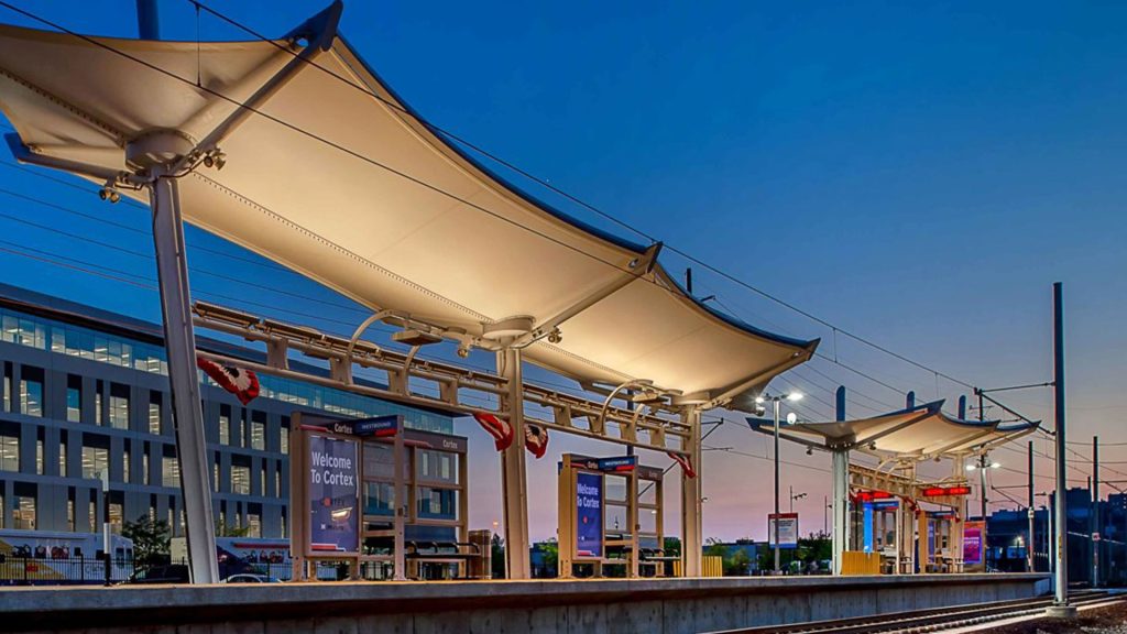 A lit up Metro platform with a dusk sky in the background.